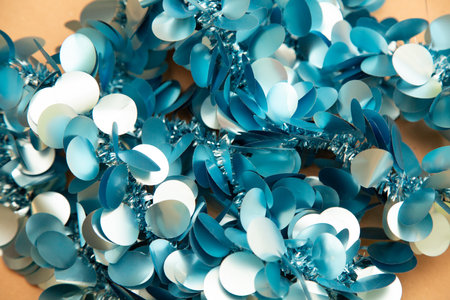 There is a cluster of blue and white sequins scattered on a tableの写真素材