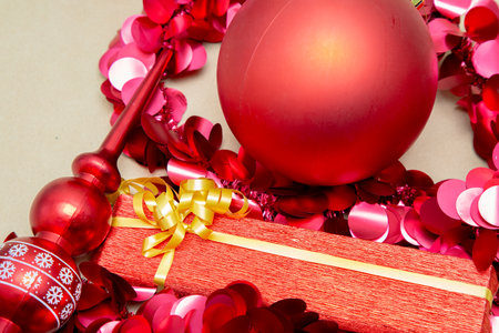 A vibrant red christmas ball is elegantly placed atop a lovely red gift boxの写真素材