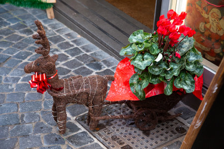 A statue of a reindeer pulling a cart full of colorful flowersの写真素材