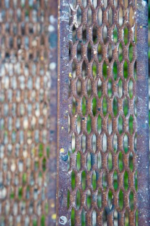 This is a closeup view of a rusty metal grate that has holes in itの写真素材