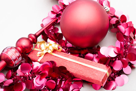 A red Christmas ornament surrounded by pink decorations.の写真素材