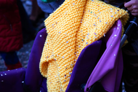 A vibrant yellow scarf is beautifully hanging on a purple chair