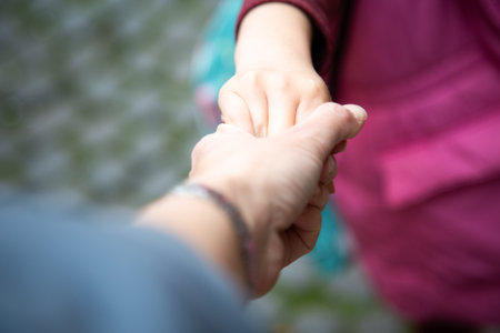 Closeup of a person holding another persons handの写真素材
