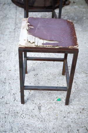 A wooden chair with a purple seat is on a concrete floorの写真素材