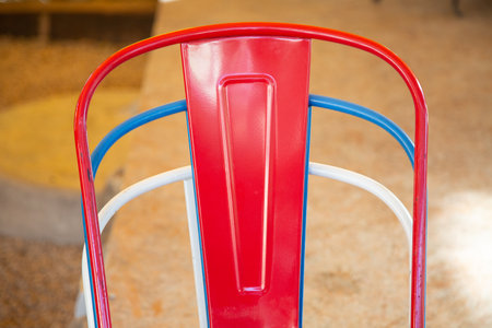 A chair that is red, white, and blue is currently sitting on a tiled floorの写真素材