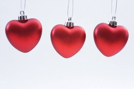Three red heart ornaments isolated on a white backgroundの写真素材