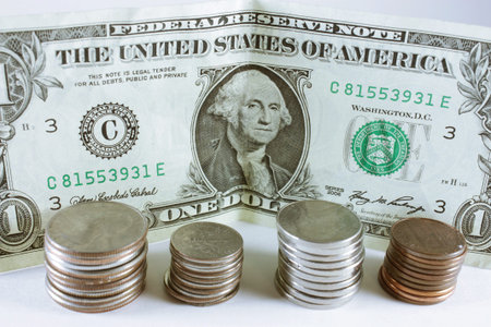 Piles of coins and a dollar bill isolated on white background