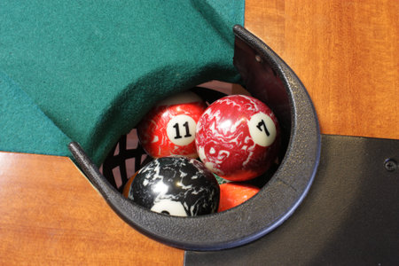 A pool table basket full of pool balls
