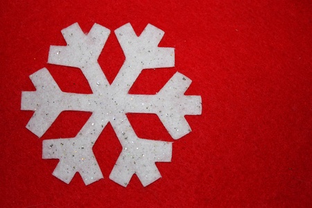 White glitter snowflake on a background of redの写真素材