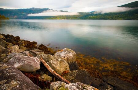 Bank of the fjord with stones and turquoise waterの写真素材