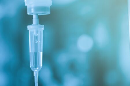 Saline iv bag intravenous drip hospital room Medical Concept treatment and injection vitamin natural drug infusion care chemotherapy concept.green light background hospital Selective focusの写真素材