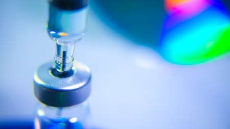 Vaccine vial dose flu shot drug needle syringe,medical concept vaccination hypodermic injection treatment disease care hospital prevention immunization illness disease  baby child.blue backgroundの写真素材