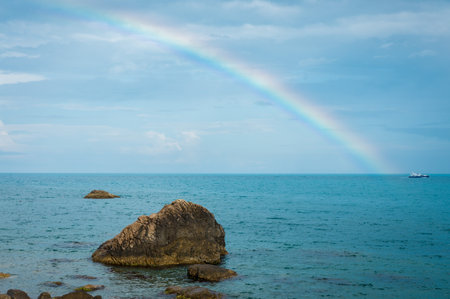 Rainbow on the sea horizon. Small ship. Backgroundの写真素材