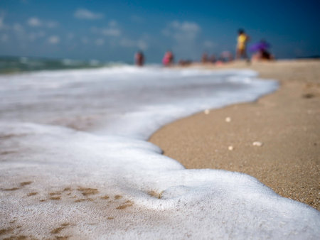 Tidal wave sea foam on sandy beach. backgroundの写真素材