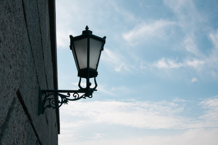 Old street lamp on the wall against the background of the evening blue skyの写真素材