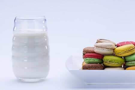 close up shot of various kind of fresh macaroons arrangement with a glass of milk の写真素材