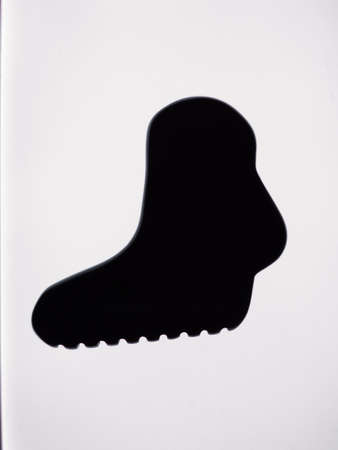 A closeup shot of a black shoe silhouette on a white backgroundの写真素材