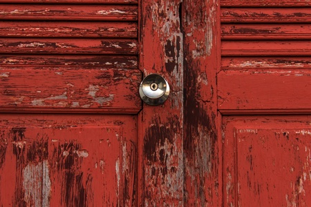 Old door red wood  peeling paint and knobの写真素材