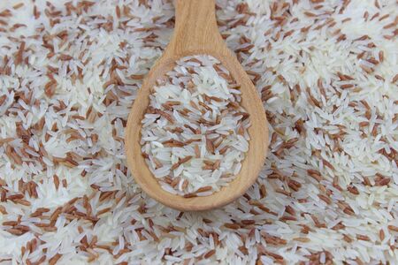 Red and white rice on spoonの写真素材