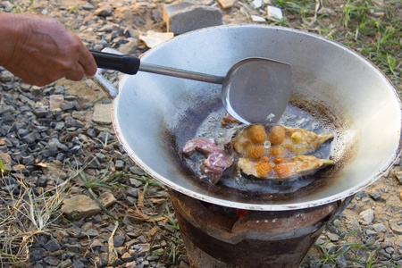Fried fish in a frying pan by brazier ,Thai Cuisine の写真素材