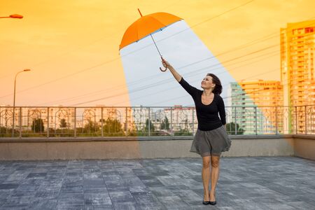 Global warming woman holding an umbrella is in a comfortable climateの写真素材