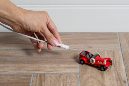 Electric red car being plugged - EV transport concept.