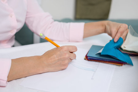 Interior designer draws at desk in office  with pencil
