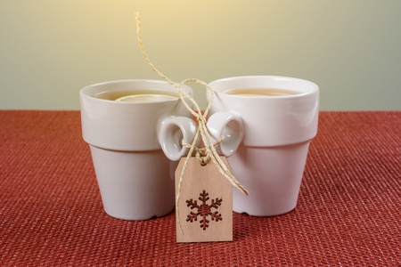 Couple cups of tea with a lemon on the table, a winter symbol-snowflake. Holidays, christmas, winter, food and drinks concept.の写真素材