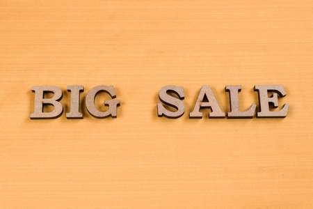 Word BIG SALE abstract wooden letters, background yellow silk textureの写真素材