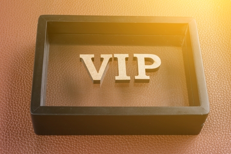 VIP is written in abstract letters in a black frame. Brown leather textured backgroundの写真素材