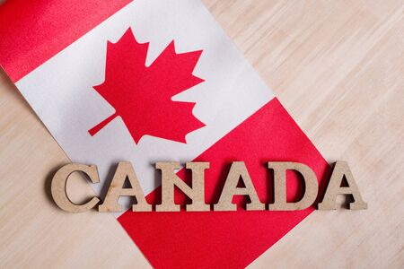 Flag of Canada, the word Canada in wooden abstract letters, wooden backgroundの写真素材