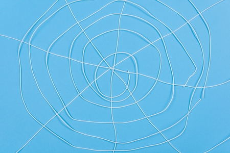 Abstract spiderweb, white threads on blue background.の写真素材