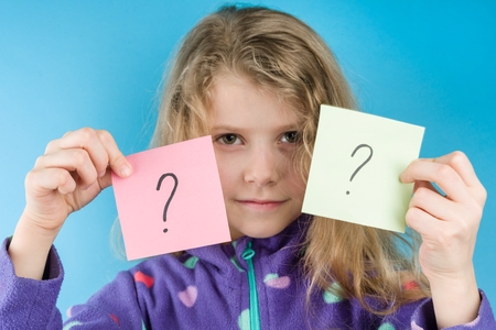 Girl holding stickers with question marks, Blue backgroundの写真素材