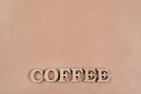 Word coffee with abstract wooden letters. Background old kraft paper, copy spaceの写真素材