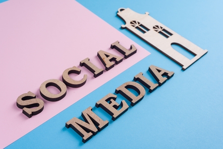 Text social media abstract wooden letters. Blue background with the image of house and pair of friends. People connecting and sharing social mediaの写真素材