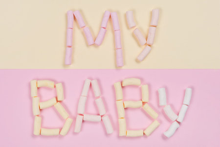 The word my baby is written by a pastel marshmallow on a white background. Backgrounds, textures.