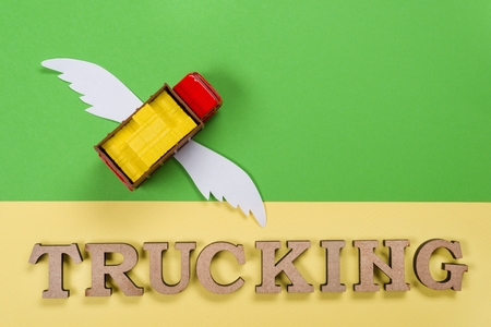 Abstract picture of a truck with wings and a word of trucking.の写真素材