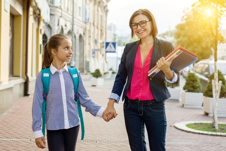 Outdoor portrait of a schoolgirl and her teacher.の写真素材