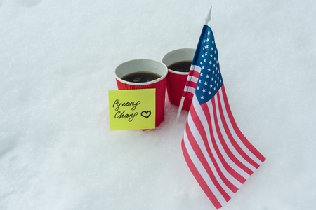2018 Winter  Games with kinds of sport in PyeongChang, Republic of Korea, the flag of the USA team, two cups of fans with coffee and a sticker - PyeongChang with love.の写真素材