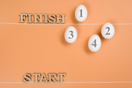 Abstract image. The word start and eggs on the way from start to finish. Egg behind the finish line