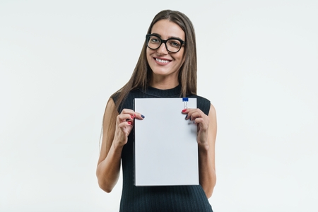 Positive smiling businesswoman showing a clean white document with copy space. White backgroundの写真素材
