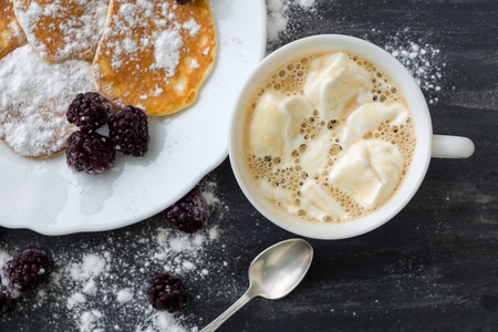 Tasty american pancakes with blackberries, powdered sugar, coffee with marshmallow. Top Viewの写真素材