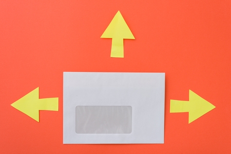 Envelope with arrows in different directions, orange background.の写真素材