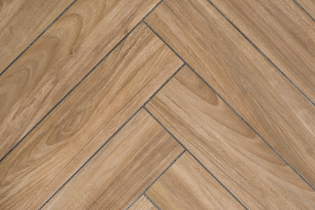 Oak wood texture of floor with tiles immitating hardwood flooring. Traditional herringbone pattern.