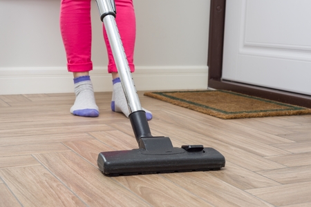 House cleaning. Woman is cleaning using vacuum cleaner.の写真素材