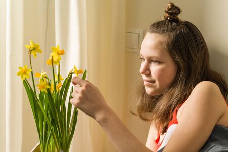 Teenage girl and bouquet of yellow spring flowers.の写真素材