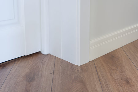 Moulding in the corner. Matte Wall with laminate immitating oak texture