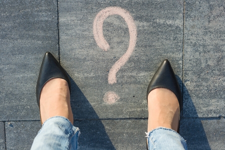 Woman feet with question mark in front of her legs painted on the asphalt.の写真素材