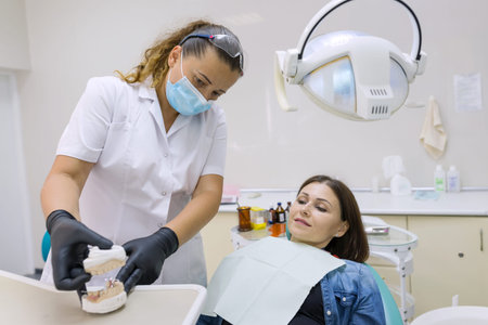 Adult female dentist treating patient woman teeth. Medicine, dentistry and healthcare concept.