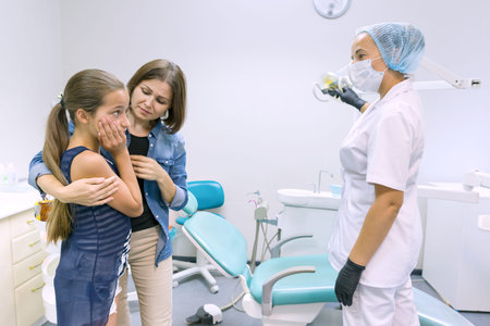 Mother and little daughter visiting pediatric dentist at dental clinics.の写真素材